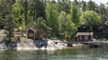 Scandinavian summer chalet by lake shore with forest Royalty Free Stock Photo