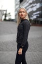 Urban scandinavian woman in workout outfit standing in the city