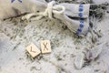 Scandinavian wooden rune Kenaz and Gebo on a rough linen cloth with amethyst crystalline, rock crystal and dried wormwood