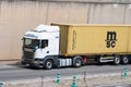 Scania R450 truck loading a yellow container trailer along Barcelona's Ronda Litoral