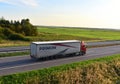 SCANIA Semi-trailer truck by `PRIMUM group` driving along highway on sunset background. Soft focus, possible granularity. MINSK, Royalty Free Stock Photo