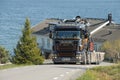 Scania truck climbing up hill with lake in the background