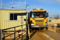 Scania Yellow Gravel Transporter truck on weighbridge on a sunny day.
