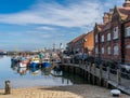 Colorful fishing boats and trawlers next to the red brick harbor building in the marina and port of Scarborough