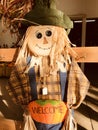 A scarecrow in a green hat wears a welcome pumpkin - HALLOWEEN - AUTUMN