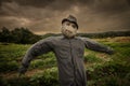 Scarecrow with a scary look at a farm with storm clouds