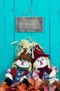 Scarecrows sitting under blank sign by fall foliage decor Royalty Free Stock Photo