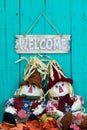 Scarecrows sitting under welcome sign with fall decor Royalty Free Stock Photo