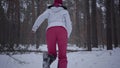 Scared African american young woman dressed warm wearing a red hat, scarf and white jacket running through the snowy