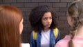 Scared afro-american schoolgirl looking elder students, bullying abuse, conflict