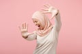 Scared arabian muslim woman in hijab light clothes posing isolated on pink background. People religious Islam lifestyle