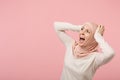 Scared arabian muslim woman in hijab light clothes posing isolated on pink background studio portrait. People religious