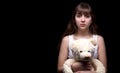 Scared blond teenage girl with teddy bear