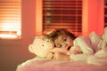 Scared boy in bed. Kid in bed with toy teddy bear. Nightmare for children. Nap and sleep time. Bedding and sleepwear for Royalty Free Stock Photo