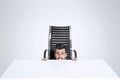 Scared business man hide himself under the office desk Royalty Free Stock Photo