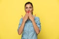 Scared casual woman gasping, covering her mouth with both hands Royalty Free Stock Photo