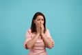 Scared caucasian female with dark hair in pink dress is covering her mouth with hands to stop screaming, feels Royalty Free Stock Photo