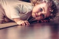 Scared child hiding under the bed in kid room and looking scared Royalty Free Stock Photo