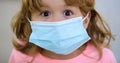 Scared child in a mask. Quarantine and coronavirus. Close-up portrait in a surgical mask. Pandemic.