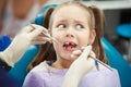 Scared child sits at dentist chair with open mouth