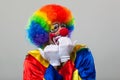 Scared clown over grey background