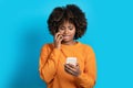 Scared young black woman looking at cell phone screen