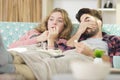 scared couple with popcorn watching film together Royalty Free Stock Photo