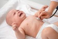 Cute baby lying on the couch during the chest auscultation Royalty Free Stock Photo