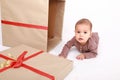 Scared baby boy in brown clothes by Christmas gift Royalty Free Stock Photo