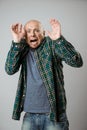 Scared emotive young man shouting over beige background.