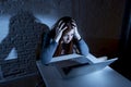 Scared female teenager with computer laptop suffering cyberbullying and harassment being online abused