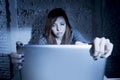 Scared female teenager with computer laptop suffering cyberbullying and harassment being online abused Royalty Free Stock Photo