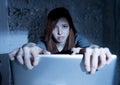 Scared female teenager with computer laptop suffering cyberbullying and harassment being online abused Royalty Free Stock Photo