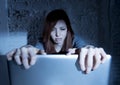 Scared female teenager with computer laptop suffering cyberbullying and harassment being online abused Royalty Free Stock Photo