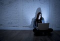 Scared female teenager with computer laptop suffering cyberbullying and harassment being online abused