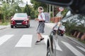 Girl with phone and headphones runs away from the car at a pedestrian crossing Royalty Free Stock Photo