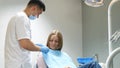 Scared girl treats teeth in a modern clinic. Cowardice and fear of the dentist.