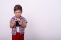 Scared kid with smartphone in his hands. Shocked child, shocking information on cell phone. Royalty Free Stock Photo