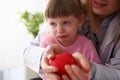 Scared little baby girl visiting doctor holding in hands red toy heart Royalty Free Stock Photo