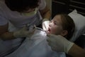 Scared little girl at dentist office, getting local anesthesia injection into gums, dentist numbing gums for dental work