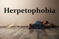 Scared little girl suffering from herpetophobia on floor. Fear or aversion to reptiles Royalty Free Stock Photo