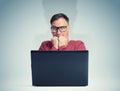 Scared man with glasses in front of laptop. Fear emotion concept Royalty Free Stock Photo