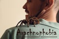 Scared man with tarantula on background, closeup. Arachnophobia fear of spiders Royalty Free Stock Photo