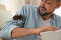 Scared man with tarantula at home. Arachnophobia fear of spiders Royalty Free Stock Photo