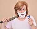Woman with shaving foam on her face holding a knife and a razor Royalty Free Stock Photo
