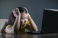 Scared and overwhelmed Asian Korean girl looking stressed at laptop computer feeling depressed and frightened in cyber bullying co