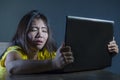 Scared and overwhelmed Asian Korean girl looking stressed at laptop computer feeling depressed and frightened in cyber bullying co