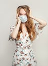 Scared panicking woman wearing a face mask on white background. Flu epidemic and covid-19 concept