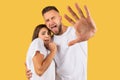 Scared sad young european couple in white t-shirts make stop gesture with hand Royalty Free Stock Photo