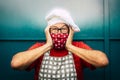 Scared and surprised adult man with red face protection mask for coronavirus - concept of restaurant owner worried for lockdown Royalty Free Stock Photo